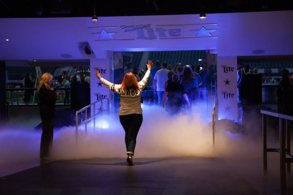 Grand entrance into football stadium by lady with her hands up